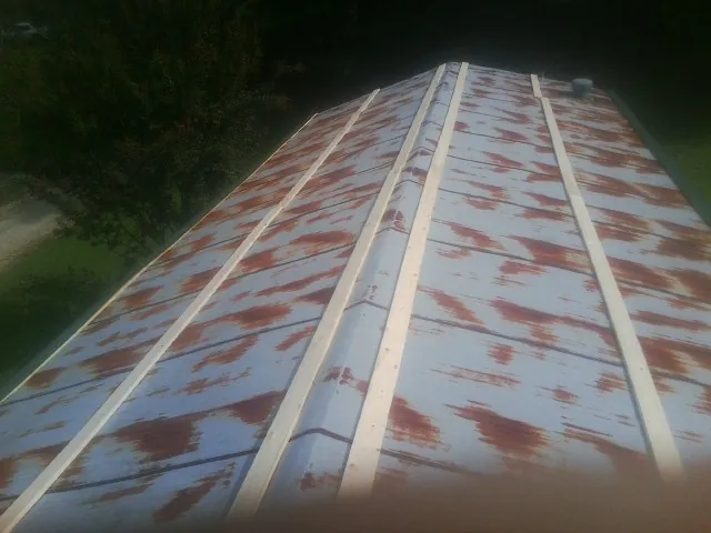 Rusted metal roof panels with new wood purlins before replacement — Storm Damage Roof Repair in Hewlett by Roofing Brothers