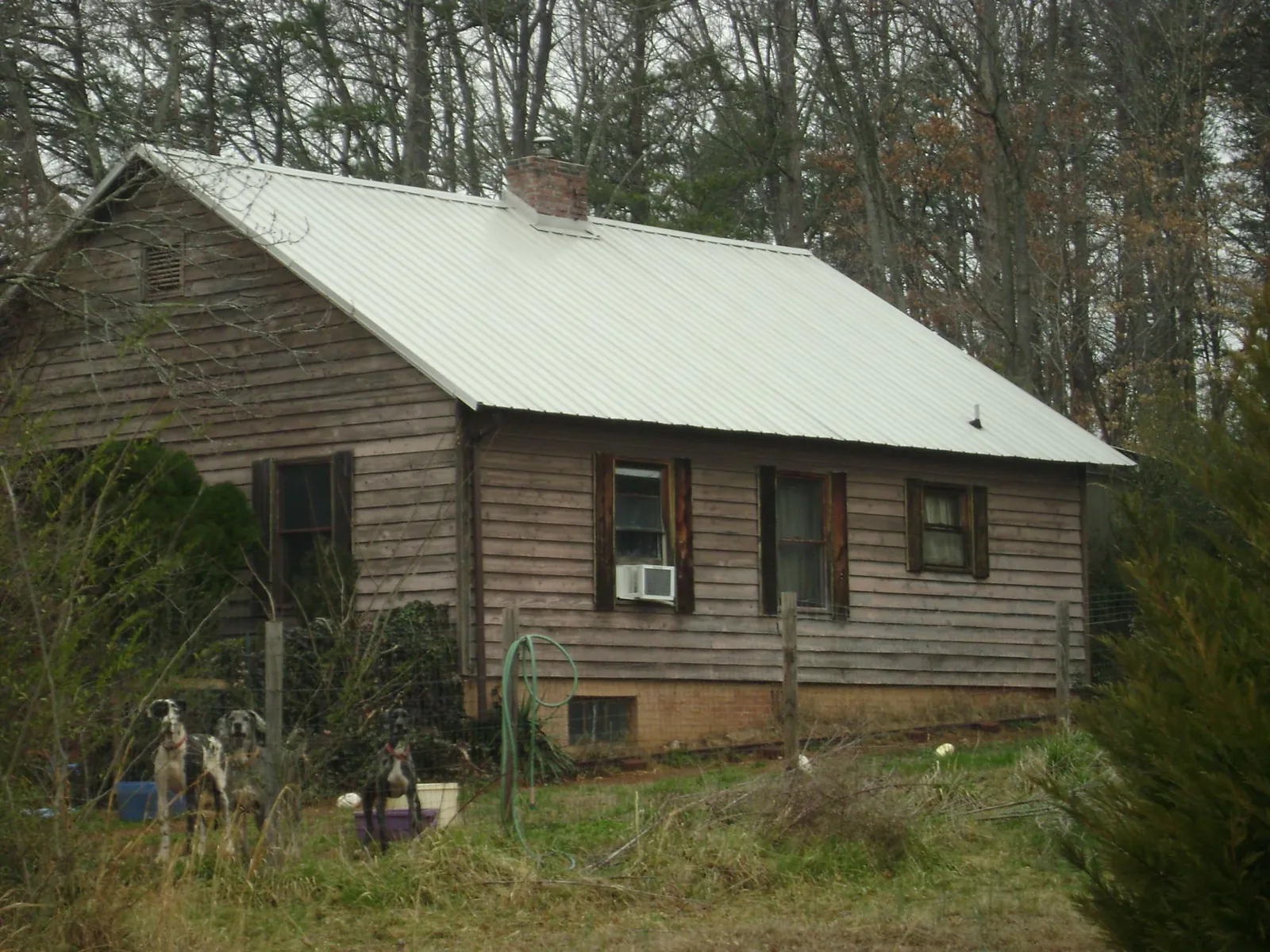White metal roof on an old wood sided farmhouse, from a Metal Roof Installation job in Hewlett